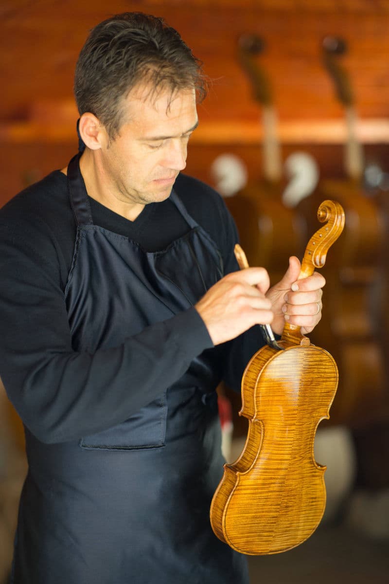 Paul Simon crafting a violin in his workshop