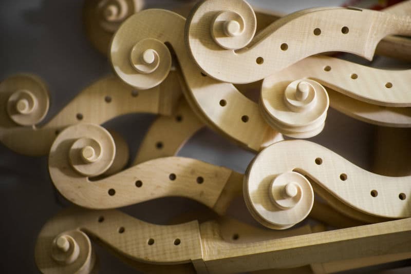 Collection of hand-carved violin scrolls showing traditional craftsmanship